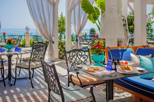 a patio with tables and chairs with food on it at Grand Hotel San Pietro Taormina in Taormina