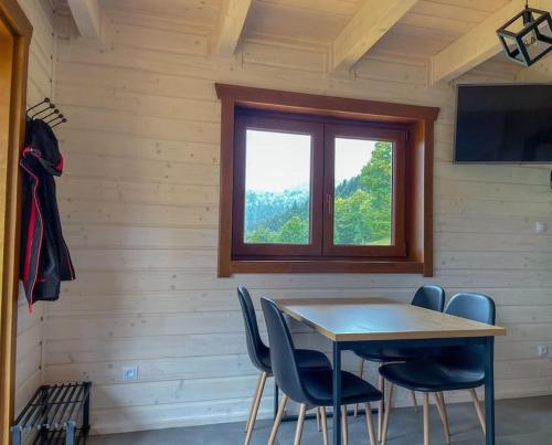 mesa y sillas en una habitación con ventana en Blisko natury - chatka z sauną w Zawoi, en Zawoja