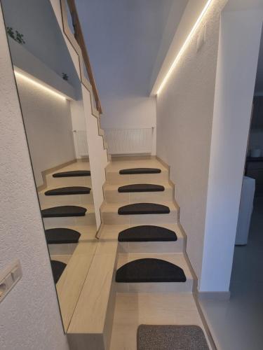 a hallway with a row of stairs with black mats at Andreea's place in Braşov
