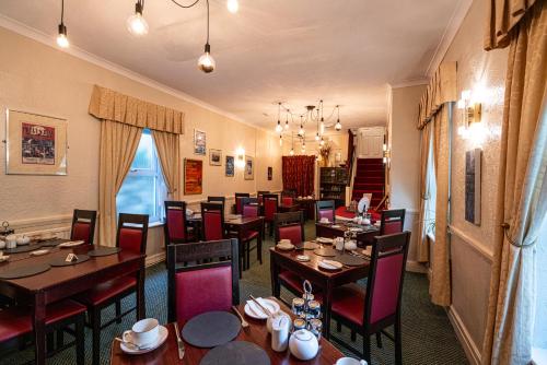 un comedor con mesas y sillas en un restaurante en Can-Y-Bae Hotel en Llandudno