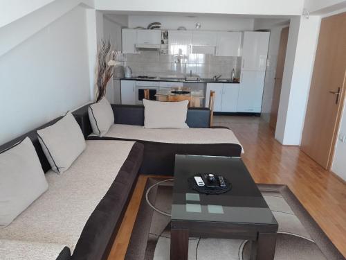 uma sala de estar com um sofá e uma mesa em Apartman Edina em Ohrid