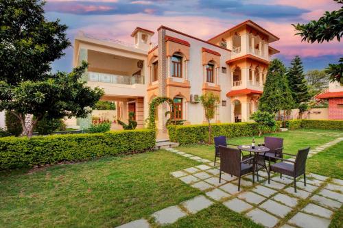 a house with a table and chairs in the yard at Arna Villa by VEO - Part of StayVista in Udaipur