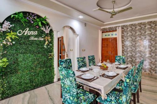 a dining room with a table and a green wall at Arna Villa by VEO - Part of StayVista in Udaipur