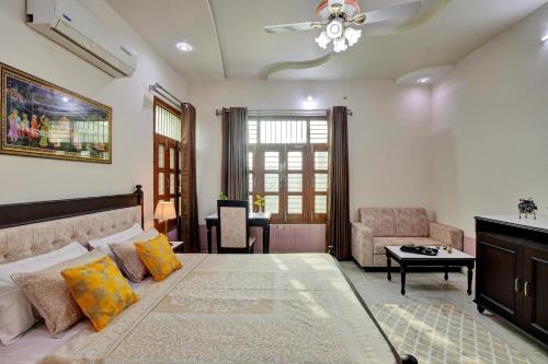 a bedroom with a large bed and a living room at Arna Villa by VEO - Part of StayVista in Udaipur