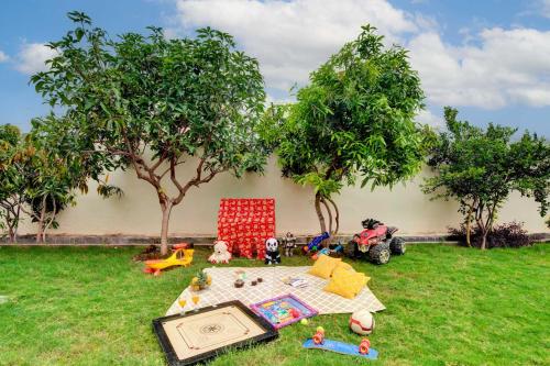 un grupo de juguetes en un patio con una mesa en StayVista's Arna Homestays - Cozy Rooms with Mountain View, Garden & Terrace, en Udaipur