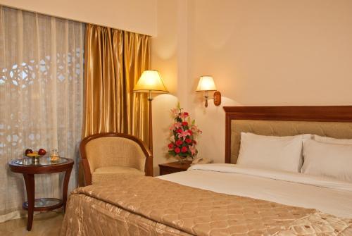 a hotel room with a bed and a chair at Clarion Bella Casa at Airport in Jaipur