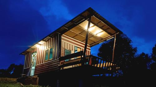 a house with lights on the front of it at night at ไร่นิธิสุนทร nithisoonthon farmstay in Mae Hong Son