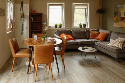 una sala de estar con una mesa y un sofá en Vrijvakantiehuis Duinweg 2b, en Oostkapelle