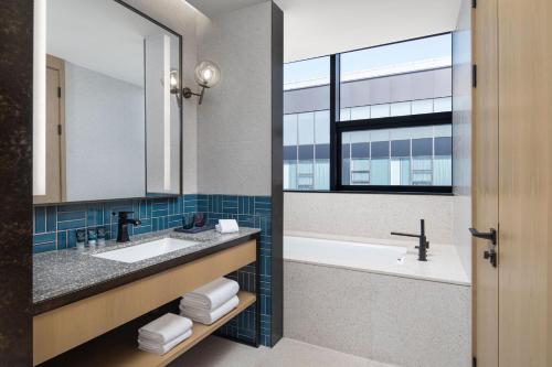 a bathroom with a sink and a tub and a mirror at Four Points by Sheraton Shanghai Hongqiao in Shanghai