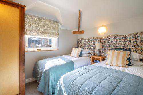 1 Schlafzimmer mit 2 Betten und einem Fenster in der Unterkunft 3 The Mews in York