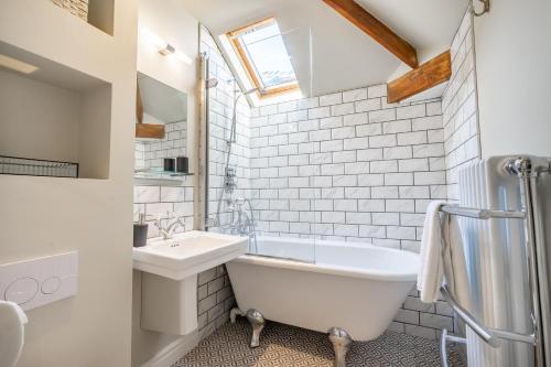 a bathroom with a white tub and a sink at 3 The Mews in York