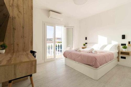 Villa Sofía Maspalomas في سان بارتولومي: غرفة نوم بيضاء مع سرير ونافذة كبيرة