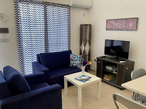 a living room with a blue couch and a tv at Loft with Garden 4 min to Beach in Kyrenia in Kyrenia