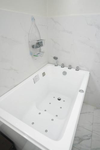 a white bath tub in a white bathroom at Luxurious Place Mountain View Spacious with WIFI Near SM Lucena in Lucena
