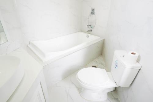 a white bathroom with a toilet and a sink at Luxurious Place Mountain View Spacious with WIFI Near SM Lucena in Lucena