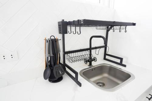 a kitchen counter with a sink and utensils at Luxurious Place Mountain View Spacious with WIFI Near SM Lucena in Lucena