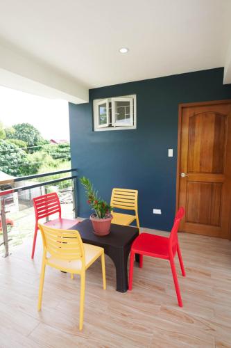 a dining room with a table and four chairs at Luxurious Place Mountain View Spacious with WIFI Near SM Lucena in Lucena