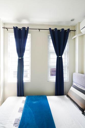 a bedroom with blue curtains and a bed at Luxurious Place Mountain View Spacious with WIFI Near SM Lucena in Lucena
