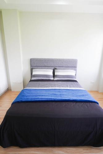 a large bed with a blue blanket on it at Luxurious Place Mountain View Spacious with WIFI Near SM Lucena in Lucena