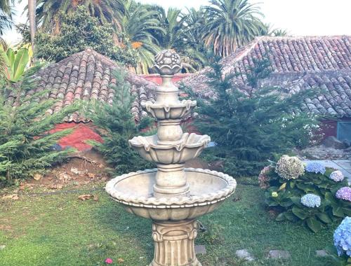een grote stenen fontein in het midden van een tuin bij Casas La Principal in San Pedro