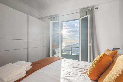 リベイラ・ブラーヴァにあるIl Tramonto by Madeira Sun Travelのベッドルーム1室(ベッド1台、大きな窓付)