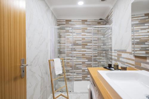 a bathroom with a white tub and a sink at Il Tramonto by Homie in Ribeira Brava