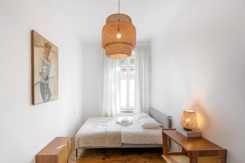 biała sypialnia z łóżkiem i oknem w obiekcie Malarskie Atelier w Toruniu