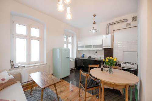 a kitchen with a table and a refrigerator at Malarskie Atelier in Toruń