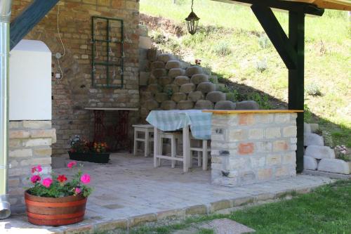 a patio with a table and a brick wall at Patrícia Pihenőház in Alsónána