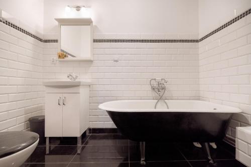 biała łazienka z wanną i toaletą w obiekcie Malarskie Atelier w Toruniu