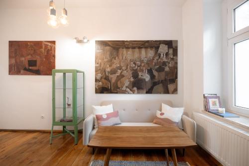een woonkamer met een bank en een schilderij aan de muur bij Malarskie Atelier in Toruń