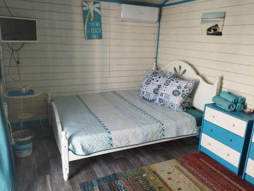 a small bedroom with a bed and a dresser at Blue Bungalow Jurilovca in Jurilovca