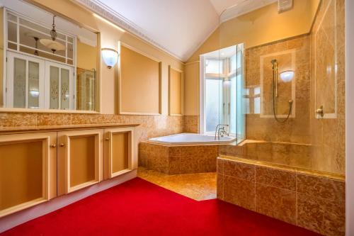 a bathroom with a tub and a shower and a sink at Aachen House in Auckland