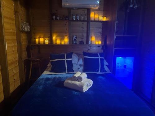 a blue room with a bed with towels on it at Ahuzat Shaul Seaside in H̱adera
