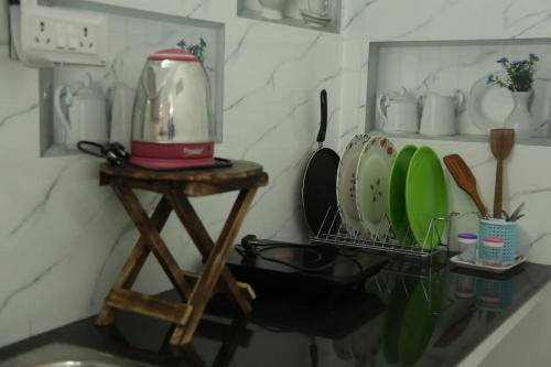 a kitchen with a stand with dishes on it at Tree shadow Guest house nearby Beach in Mahabalipuram