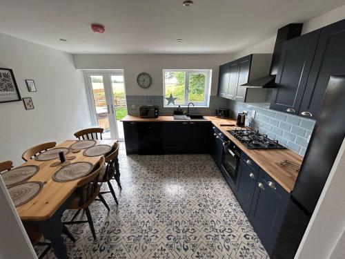 a kitchen with a wooden table and a kitchen with a dining room at 1 - Fox Burrow, Norfolk Norwich in Sparham