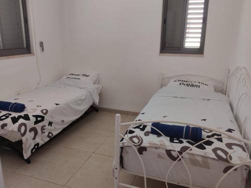 2 łóżka pojedyncze w pokoju z oknem w obiekcie פנינה בראש פינה w mieście Rosz Pina