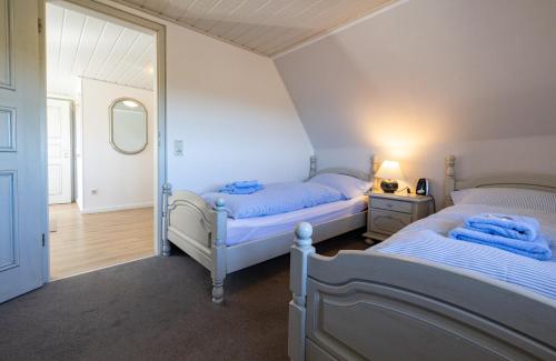 a bedroom with two beds and a mirror at Haus Amanda in Norddorf