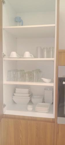 a cabinet filled with plates and bowls and dishes at Baan Tasha in Laem Sor