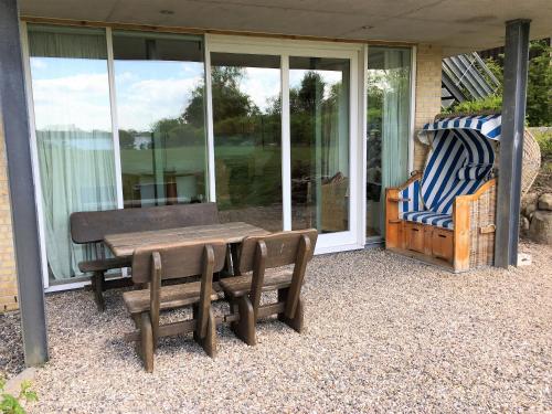 a patio with a wooden table and chairs on a house at Ferienwohnung Schleistrand in Kappeln