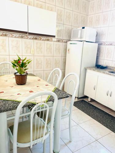 una cucina con tavolo, sedie e frigorifero di Carvalho de Muriqui a Mangaratiba