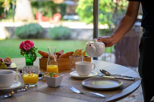 Una mesa con un desayuno de café y croissants. en Villa Augusta, en Saint-Paul-Trois-Châteaux