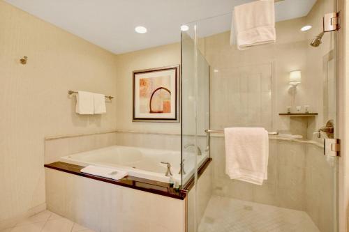 a bathroom with a bath tub and a shower at Strip View Balcony Suites - No Resort Fee ! in Las Vegas