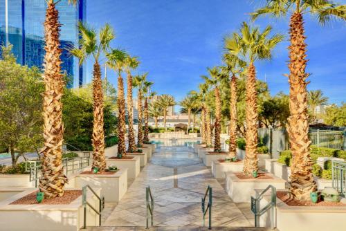 a row of palm trees on a walkway at Strip View Balcony Suites - No Resort Fee ! in Las Vegas
