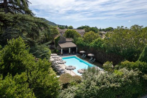 uma vista sobre uma piscina com cadeiras e uma casa em Villa Augusta em Saint-Paul-Trois-Châteaux