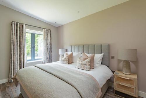 a bedroom with a large bed with pillows and a window at The Old Cherry Barn - Luxury barn conversion in Faversham