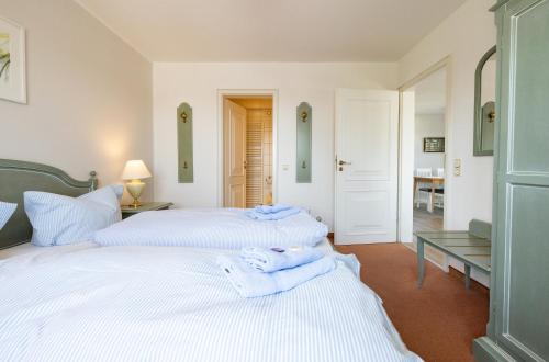 a bedroom with two beds with towels on them at Haus Amanda in Norddorf