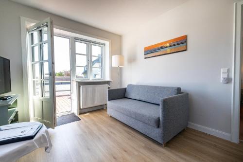 a living room with a chair and a window at Haus Amanda in Norddorf
