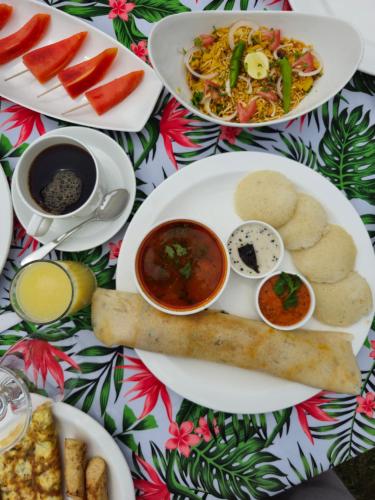 une table avec des assiettes de nourriture sur une table dans l'établissement Neemrana's Three Waters, à Betul