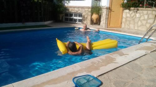 duas pessoas a flutuar numa piscina insuflável em la Vega Fuente las moreras em La Iruela